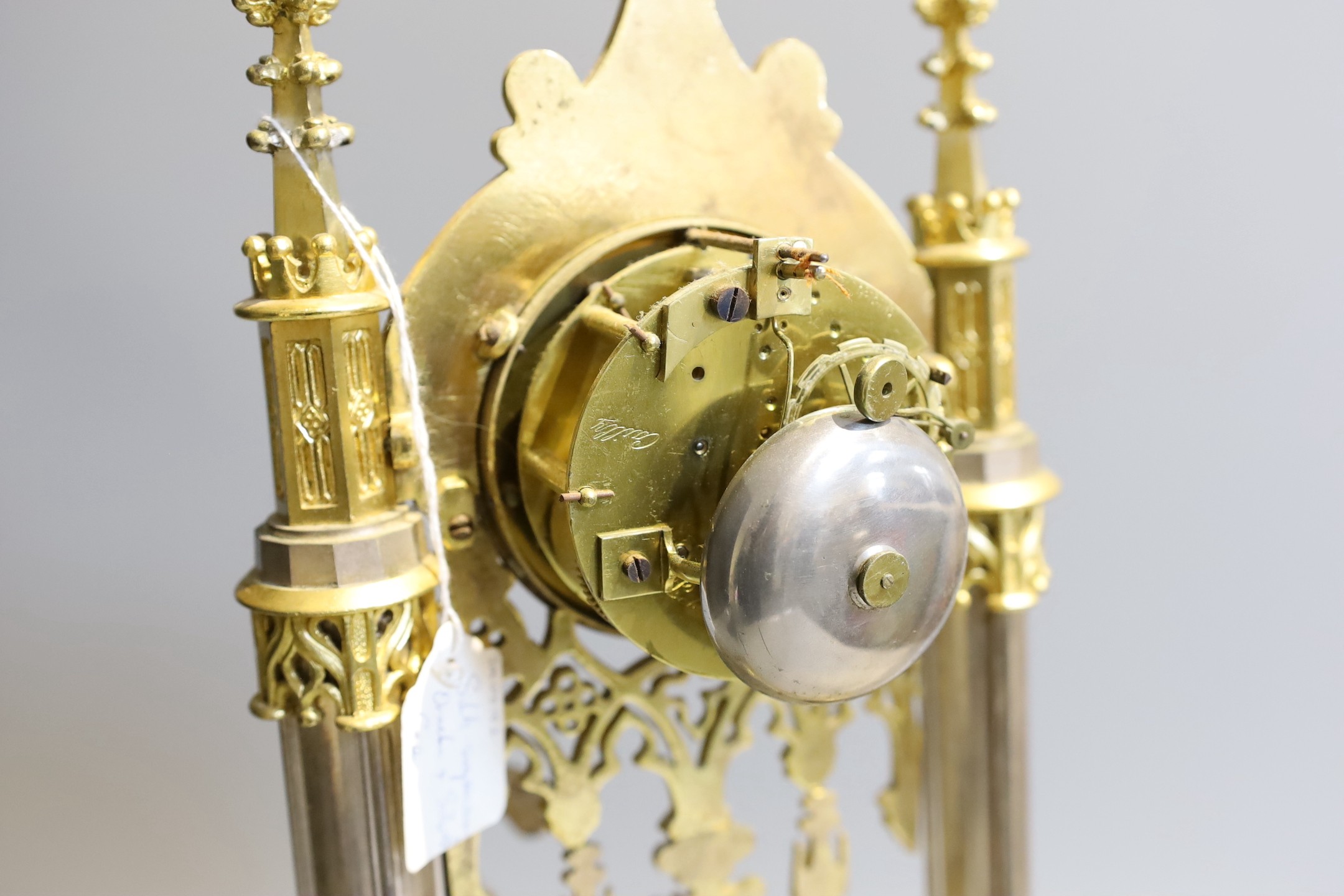 An early 19th century French silvered and gilt metal architectural 8 day mantel clock cast with a seated cavalier with lyre. Height 45 cms.